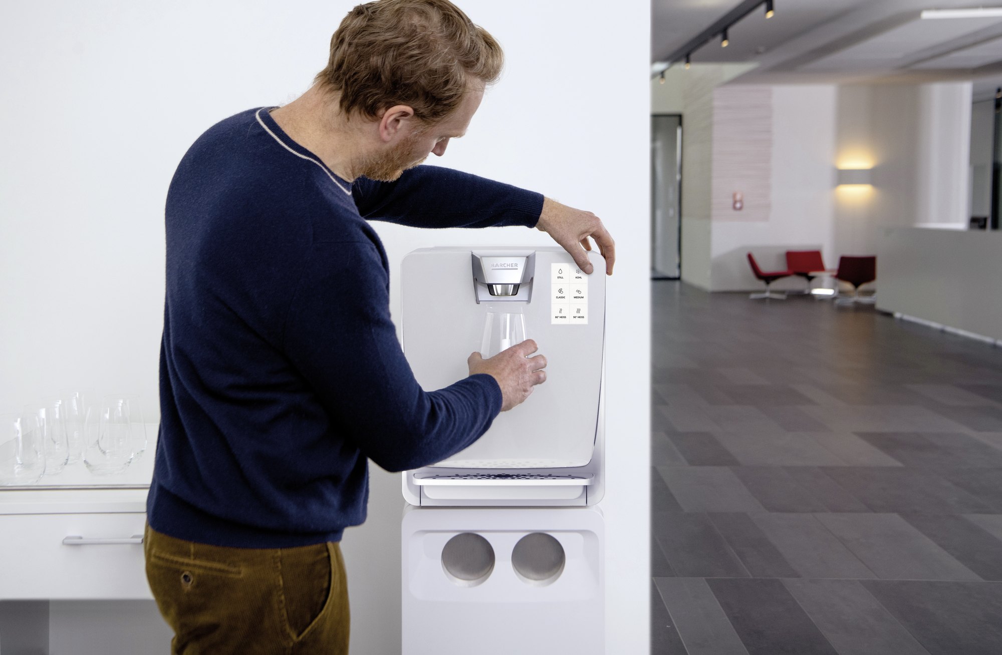 Mitarbeiter zapft Wasser am Kärcher Wasserspender im Bürofoyer